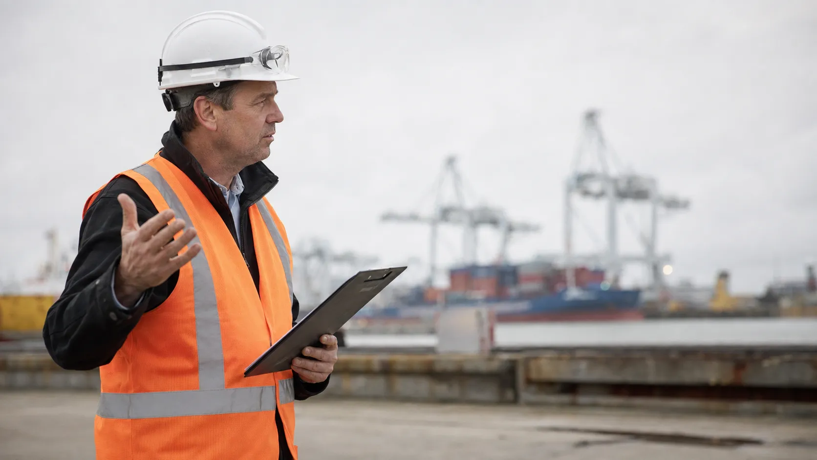 VCA veiligheidstrainer met helm en veiligheidsvest in havengebied Rotterdam